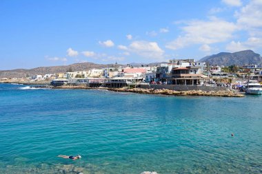 Bay Kent ve engebeli kıyı şeridi, Sissi, Crete doğru manzaralı sığ suda kadın Şnorkelle Dalma.