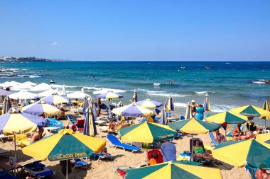Turistler deniz, Stalida, Crete doğru manzaralı sahilde rahatlatıcı.