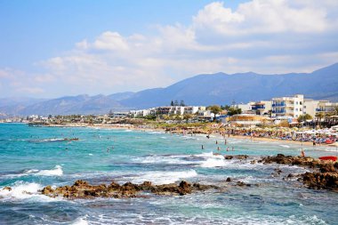 Turistler rahatlatıcı sahilde ve daireler ve arka, Stalida, Girit için otel denize sıfır.