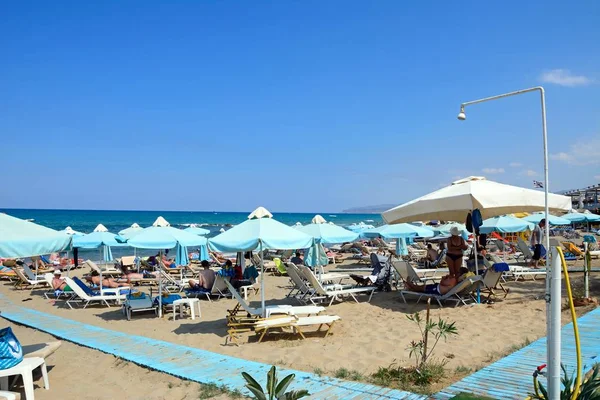 Turistler deniz, Stalida, Crete doğru manzaralı sahilde rahatlatıcı.