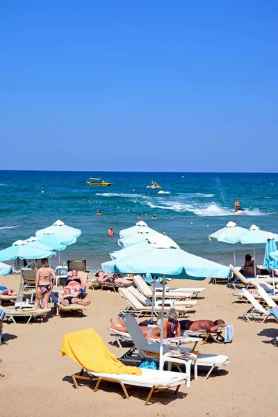Turistler deniz, Stalida, Crete doğru manzaralı sahilde rahatlatıcı.