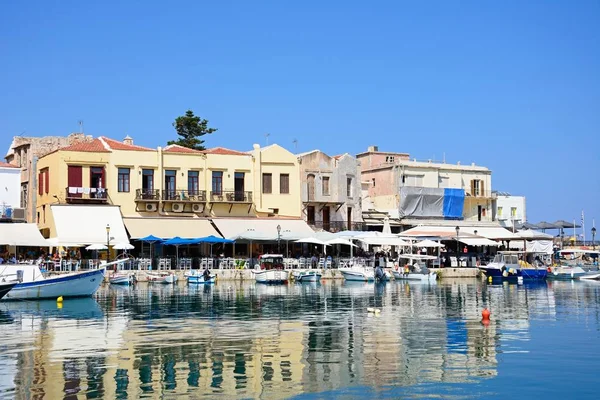 Blick auf Fischerboote und Restaurants am Wasser im Innenhafen, Rethymno, Beton. — Stockfoto