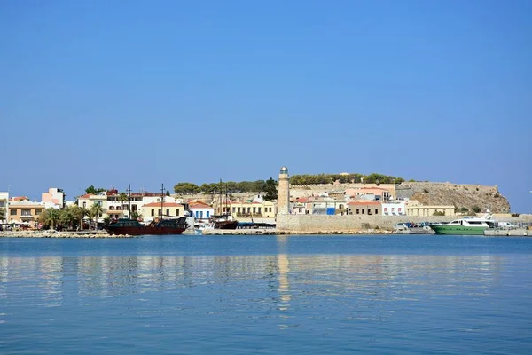 View of the harbour and lighthouse with the castle to the rear, Rethymno, Crete. — Stock Photo, Image