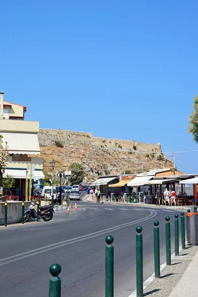 Cafés de pavimento a lo largo de Periferiakos con el castillo en la parte trasera, Rethymno, Creta . — Foto de Stock