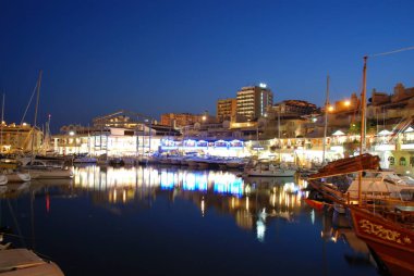 Yatlar ve restoranlar ve liman alacakaranlıkta, Benalmadena, İspanya.