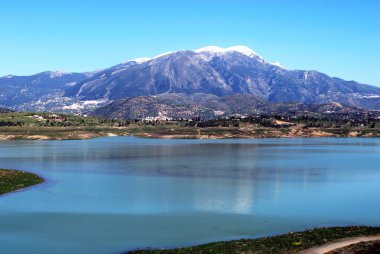 Arkaya kar kaplı dağlar ile Lake Vinuela görünümü, La Vinuela, Ispanya.