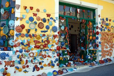 Köy merkezinde bir dükkanın duvarında gösterilen çömlekçilik, Margarites, Girit, Yunanistan.