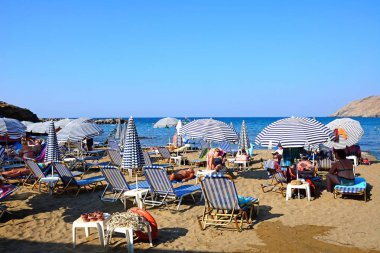 Ege Denizi, Panormos, Girit manzarasına sahip kumlu plajda rahatlatıcı turistler.