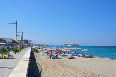 Kumlu plajda rahatlatıcı turistler, Perivolia, Girit, Yunanistan.