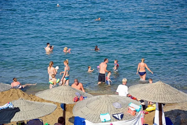 Turistas relajándose en la playa de arena y en el mar, Panormos, Creta . — Foto de Stock