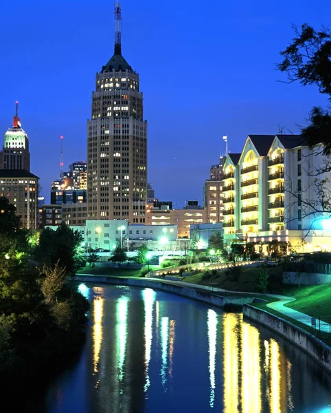 Blick entlang des Flusses San Antonio in Richtung städtischer Gebäude bei Nacht, San Antonio, USA. — Stockfoto