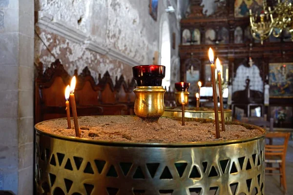 Prayer candle in sand inside the Arkadi Monastery church, Arkadi, Crete. — Stock Photo, Image