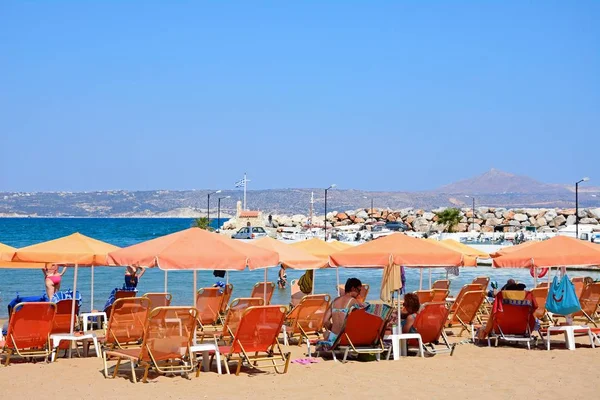 Turistas relaxando na praia com vista para as montanhas, Kalyves, Creta . — Fotografia de Stock
