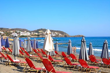 Şezlonglar ve Livadi Beach turistlerin sayısı boyunca kıyı şeridi, Bali, Crete.