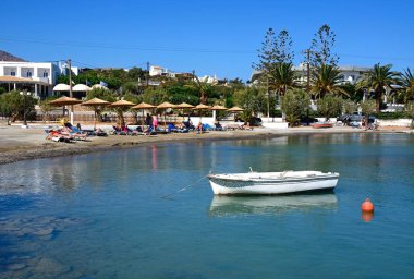 Kasabanın, Agios Nikolaos, Crete üzerinde küçük bir plaj rahatlatıcı turistlere.