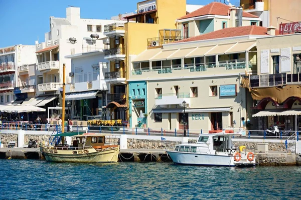 Vissersboten in de innerlijke haven met waterkant restaurants aan de achterzijde, Agios Nikolaos, Kreta. — Stockfoto