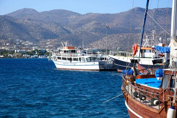 Bateau et bateaux de croisière dans le port avec le littoral montagneux à l'arrière, Agios Nikolaos, Crète . — Photo