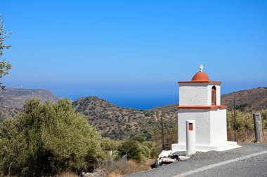 Elounda, Crete yakınındaki denize doğru manzaralı bir dağ yolunda küçük Tapınak.