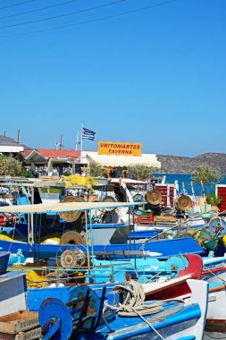 Geleneksel Yunan balıkçı tekneleri ile bir taverna arkaya, Elounda, Crete limanında demirlemiş.