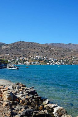 Bay doğru ile ön plan, Elounda, Girit'te kayalık kıyı kıyı şeridi boyunca görüntülemek.