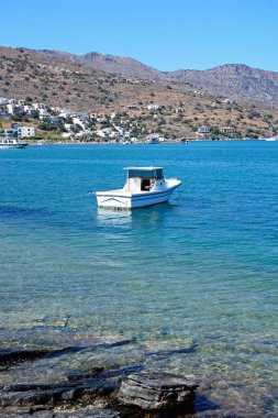 Bay arkaya, Elounda, Crete kıyı şeridi ile küçük tekne palamarla.