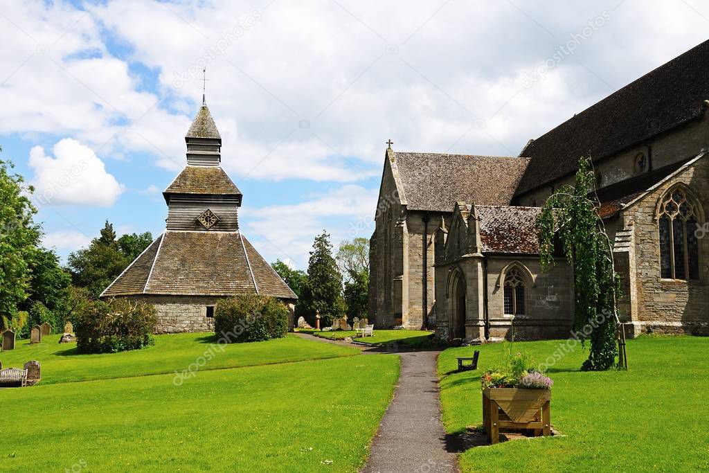 View along the side of St Marys church towards the separate bell tower, Pembridge, UK.