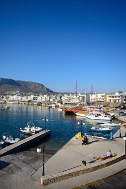 Tekneler ve gemiler şehir ve dağlar, Hersonissos, Crete doğru manzaralı limanında demirlemiş.