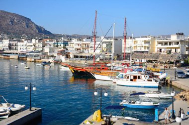 Tekneler ve gemiler şehir ve dağlar, Hersonissos, Crete doğru manzaralı limanında demirlemiş.