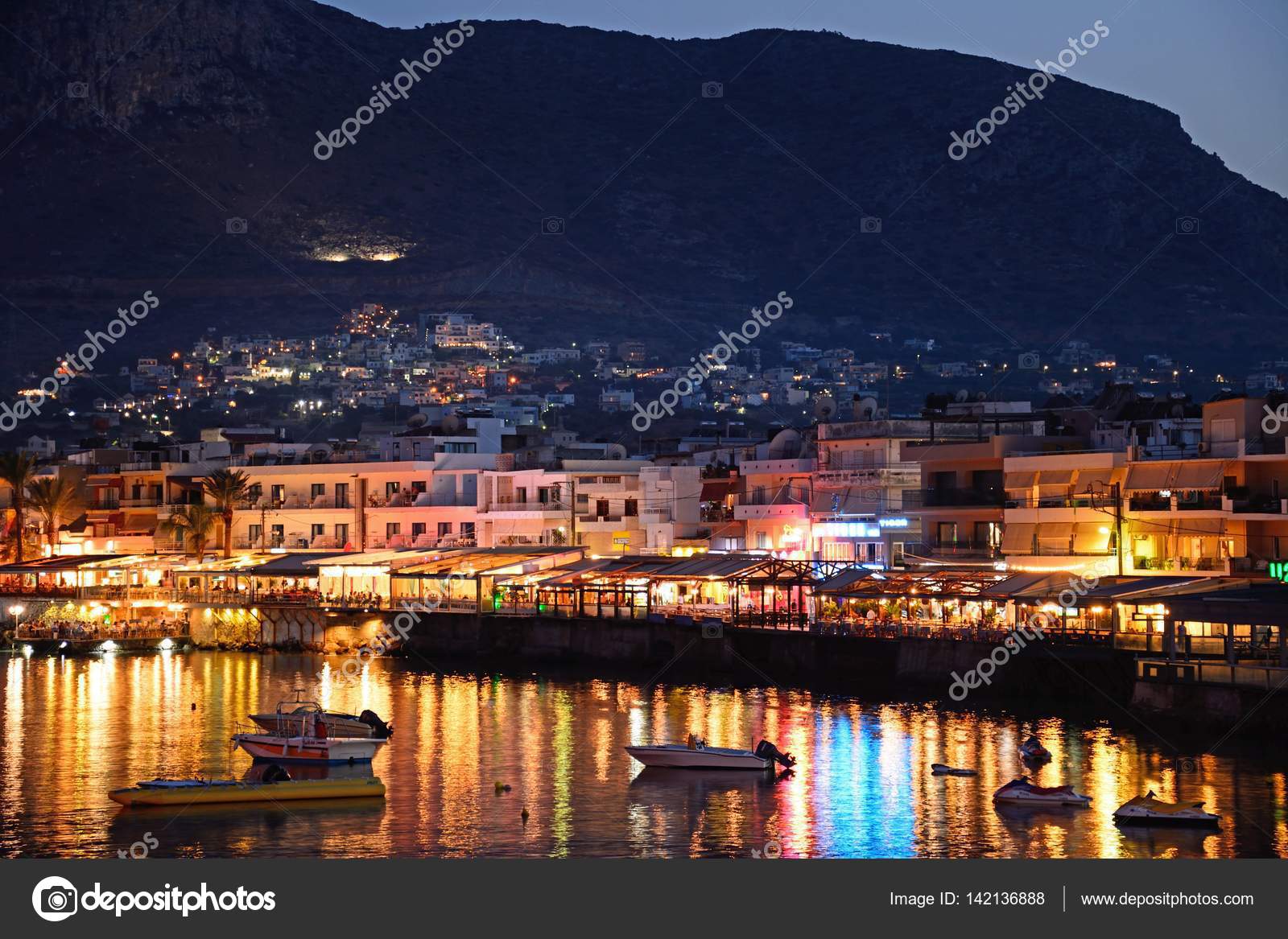 View of harbour and waterfront restaurants at dusk, Hersonissos, Crete