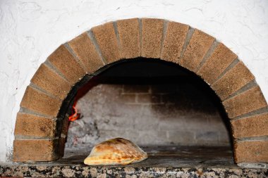 Freshly cooked Calzone in a wood fired oven, Hersonissos, Crete. clipart