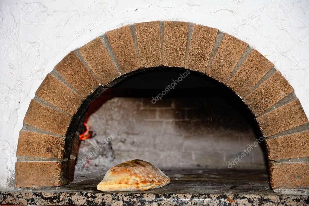 Freshly cooked Calzone in a wood fired oven, Hersonissos, Crete.