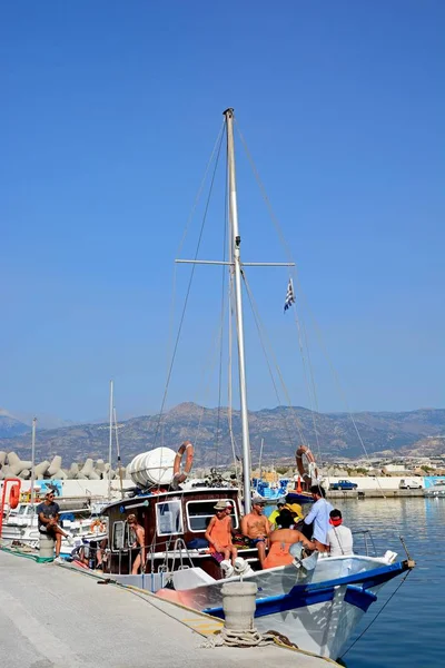 Groupe de personnes sur un yacht amarré dans le port avec vue sur les montagnes, Ierapetra, Crète . — Photo