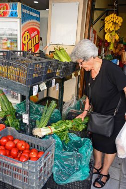 Meyve ve sebze Odos 1821, Kandiye, Crete boyunca bir şehir merkezi dükkanında seçme müşteri.