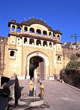 Kadın ve çocuk hazır bir çeşme giriş dışında Samode saraya Samode, Hindistan.