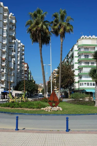 Isla de tráfico a lo largo del paseo marítimo con una escultura de barco de metal, Torre del Mar, España . — Foto de Stock