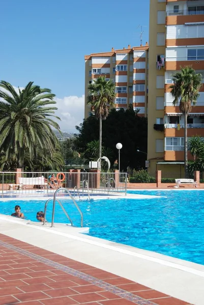 İnsanlar rahatlatıcı bir apartman kompleksi yüzme havuzunda, Lagos, İspanya.