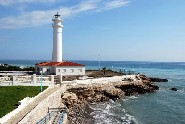 Görünüm engebeli kıyı şeridi, Torrox Costa, İspanya boyunca badanalı deniz feneri.