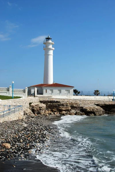 Görünüm engebeli kıyı şeridi, Torrox Costa, İspanya boyunca badanalı deniz feneri.
