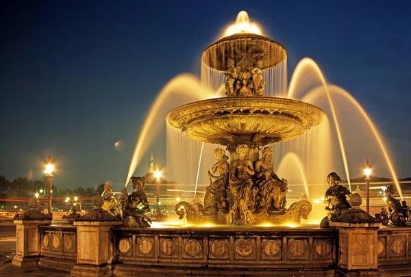 Fontána v Place de la Concorde s Eiffelovku vzadu v noci, Paříž, Francie. — Stock fotografie