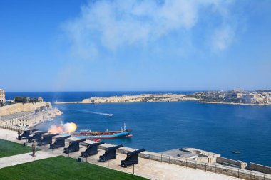 Öğlen silah selamlayan Fort Rikasoli, Valletta, Malta doğru bay üzerinde üst Barrakka bahçeleri manzaralı Marnixkade batarya.