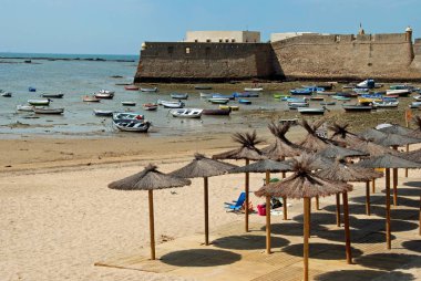 Şemsiye La Caleta sahilde Limanı ve Kalesi ile arka, Cadiz, İspanya.