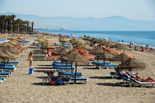 Turistas relaxando na praia com vista para as montanhas, Torremolinos, Espanha . — Fotografia de Stock