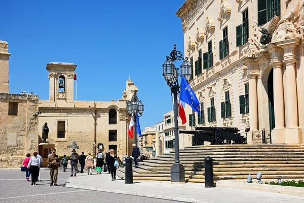 A Auberge de Castille Castille téren kilátással turista élvezte a beállítás és a Szűzanya a győzelem-templom, a hátsó, Valletta, Málta. — Stock Fotó