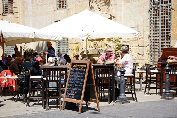 Cafés de pavimento en una pequeña plaza a lo largo de Republic Street aka Triq Ir Repubblika, La Valeta, Malta . — Foto de Stock