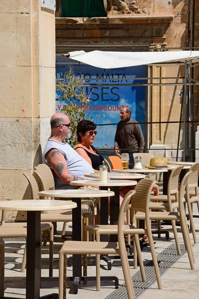Para, siedząc w kawiarni chodnika wzdłuż ulicy Republiki aka Triq Ir Repubblika, Valletta, Malta. — Zdjęcie stockowe