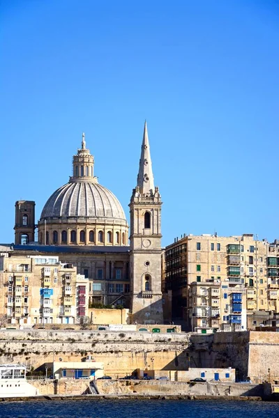 Utsikt över St Pauls Anglikansk katedral och de Basilica av vår fru av berget Karmel sett från Grand Harbour, Valletta, Malta. — Stockfoto