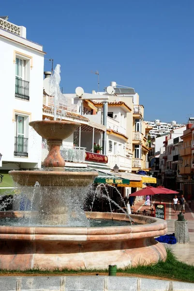 路面咖啡馆和商店在诺斯，西班牙马拉加区后方的喷泉. — 图库照片