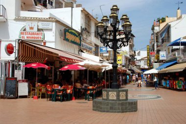 San Miguel cadde, Torremolinos, İspanya boyunca arka kaldırım kafeleri ile süslü sokak lâmbası direği.