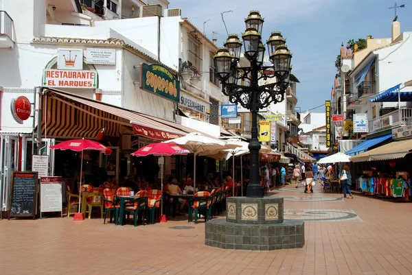 スペインのトレモリノス サン ・ ミゲル通り奥にカフェと華やかな街灯. — ストック写真