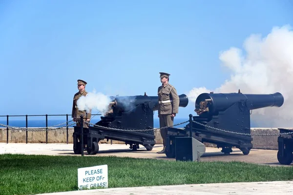 Soldater skjuta kanoner för Noon pistolen i Upper Barrakka Gardens, Valletta, Malta. — Stockfoto